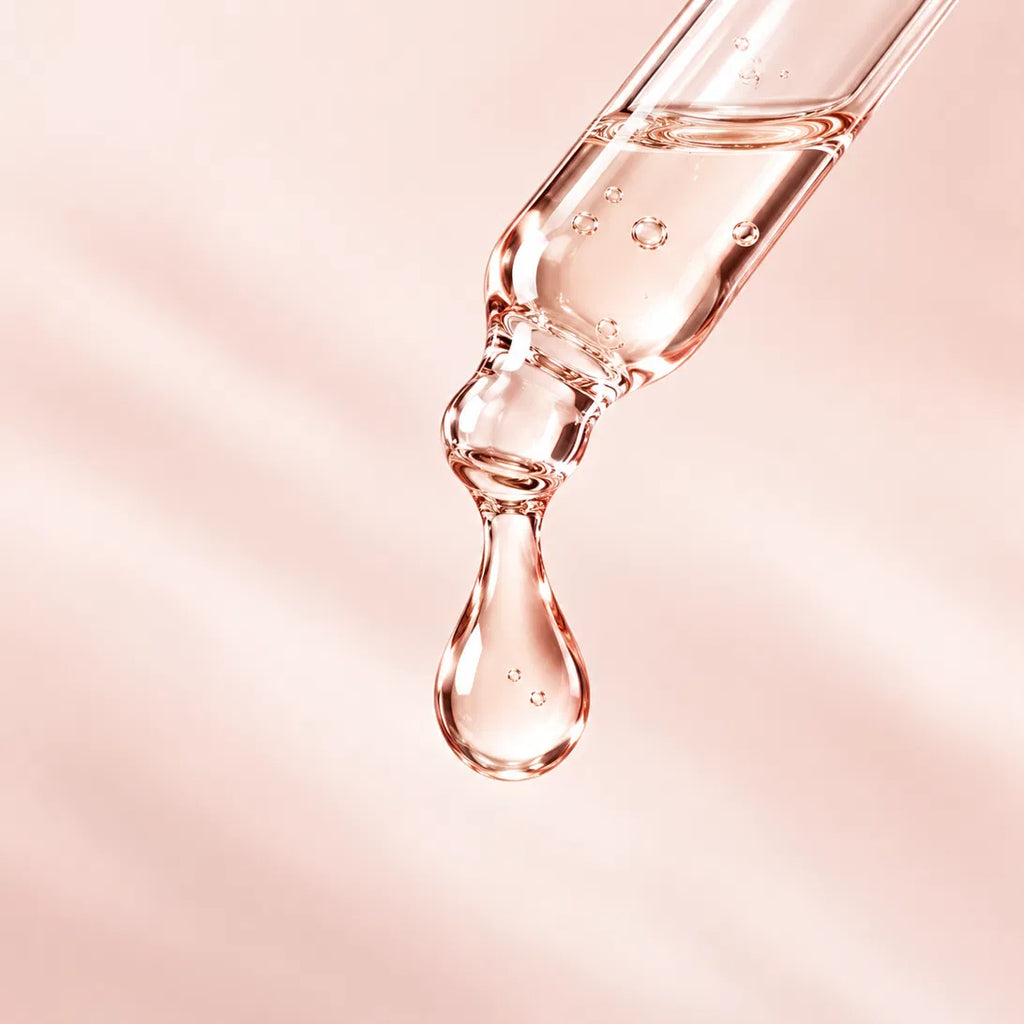 A drop of Hairtide serum falling from a glass dropper